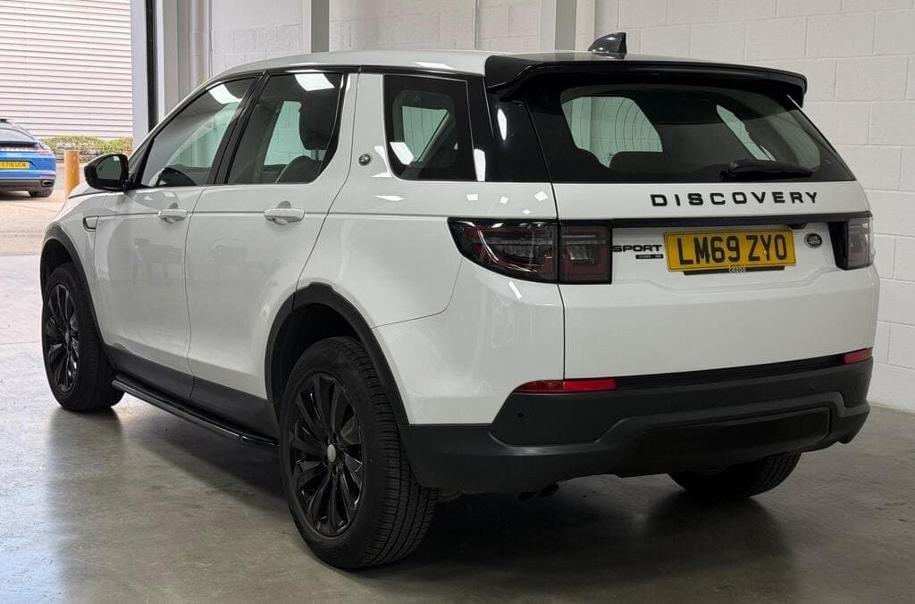 Land Rover Discovery Sport SE in Fuji White, front three-quarter view, showroom setting